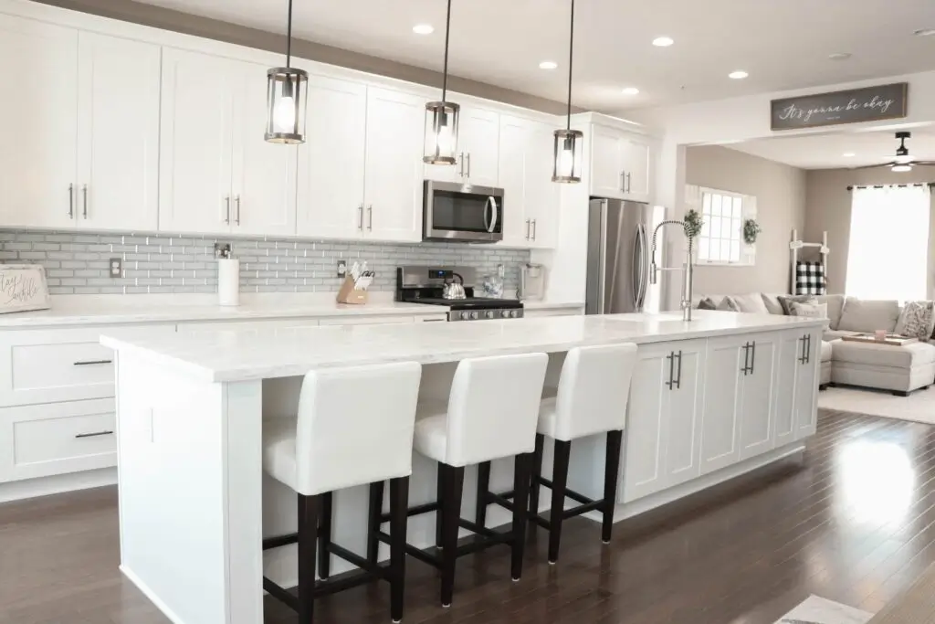 Newly remodeled kitchen with natural stone counter and Kraftsman Cabinetry in White Shaker color