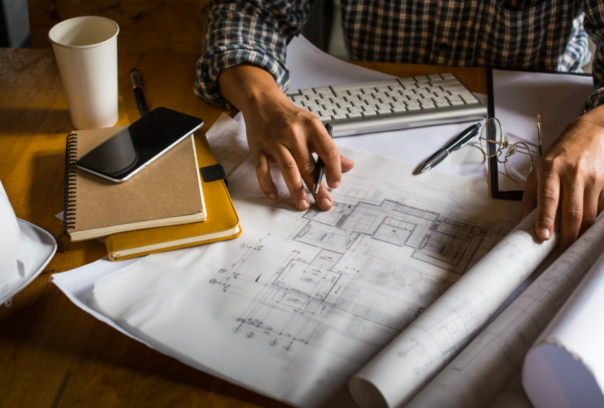 Architect reviewing construction plans and technical drawings